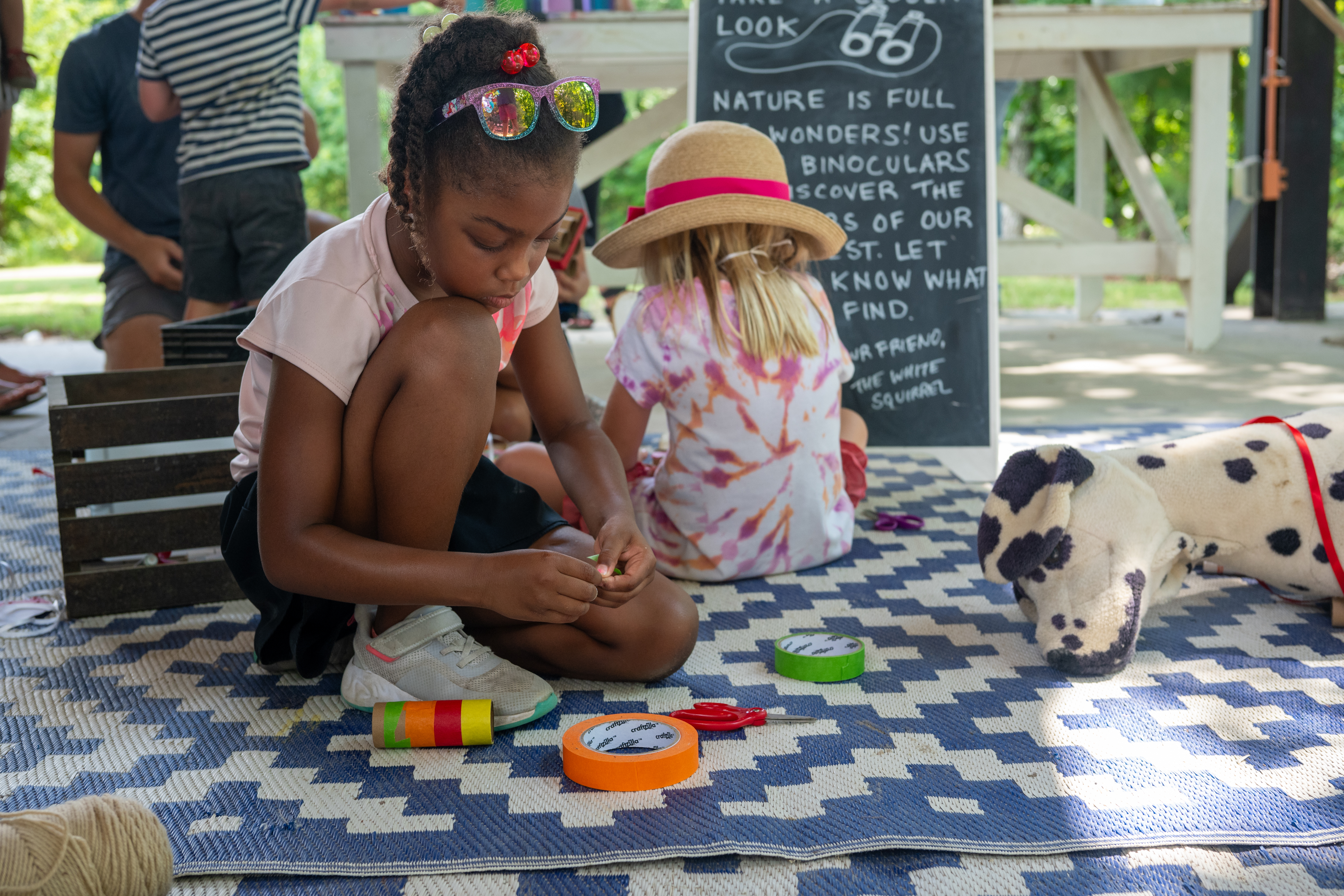 girl decorating binoculars with tape